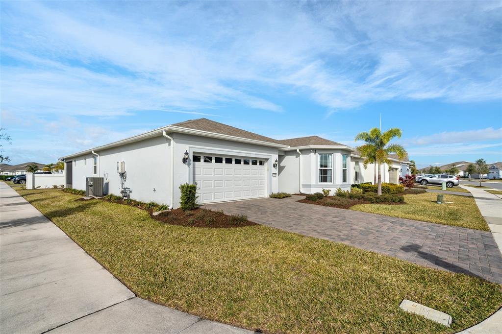 A single-story house with a white exterior, a two-car garage, and a paved driveway — 13360 SUNNY RETREAT LANE, WINTER GARDEN, FL