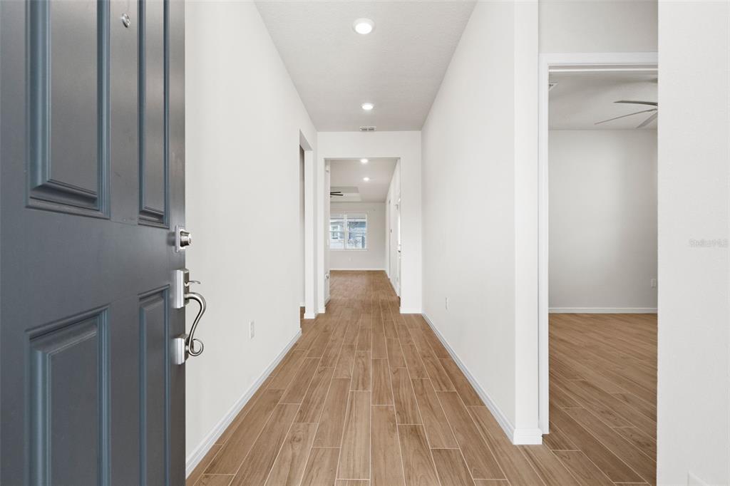 A view from an open front door into a hallway with wood-look tile flooring — 13360 SUNNY RETREAT LANE, WINTER GARDEN, FL