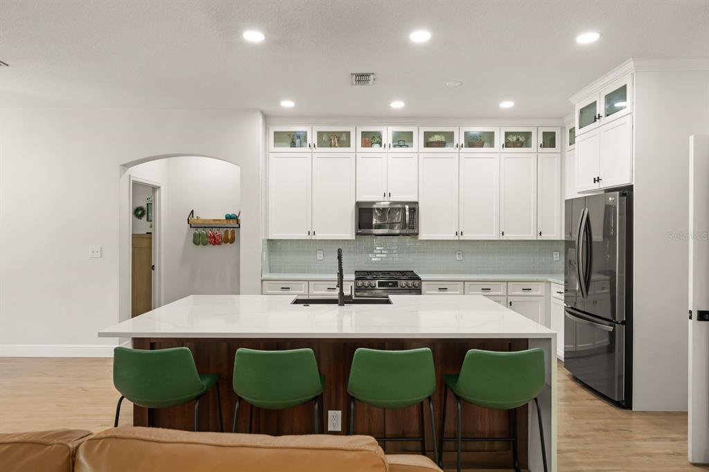 A dining room features a dark wood table with a bench, chairs, and a pendant light — 611 BROOKFIELD TERRACE, DELAND, FL
