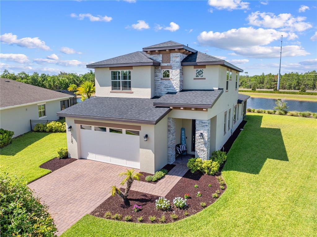 A two-story house with a stone-accented facade, a two-car garage, and a landscaped yard — 3120 CRISPIN, ST CLOUD, FL