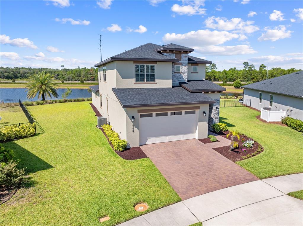 An aerial view of a two-story house with a paved driveway and a side yard — 3120 CRISPIN, ST CLOUD, FL