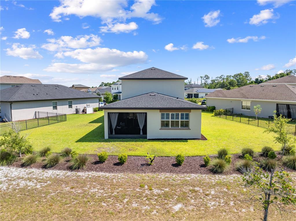 The rear exterior of a two-story house features a screened-in patio and a fenced yard — 3120 CRISPIN, ST CLOUD, FL