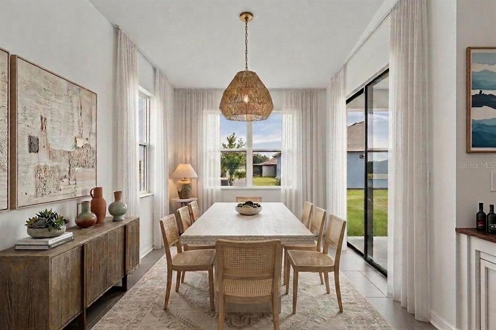 A dining room features a long wooden table, cane chairs, a textured pendant light, and curtains — 11837 MOONSAIL DRIVE, PARRISH, FL