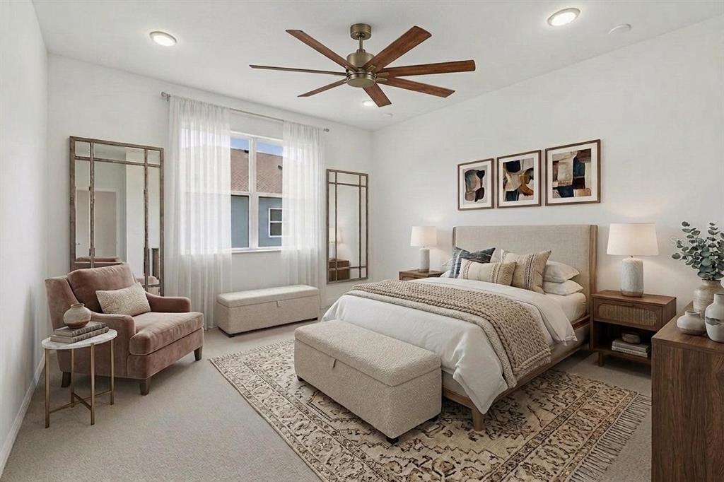 This bedroom features a bed, a velvet armchair, a ceiling fan, and two large mirrors — 11837 MOONSAIL DRIVE, PARRISH, FL