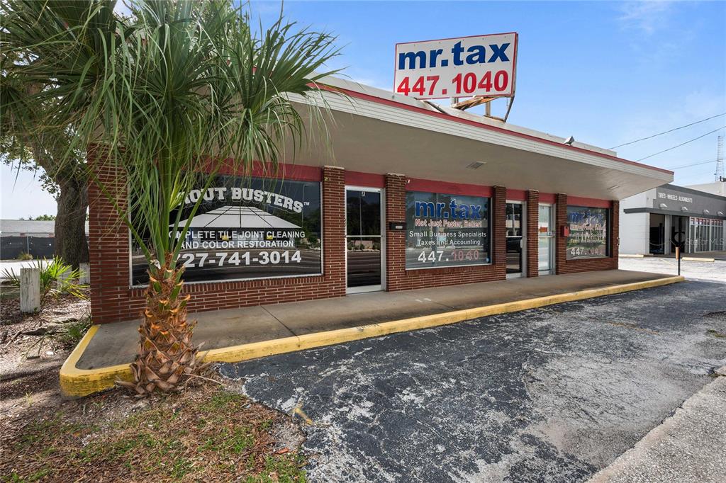 A one-story commercial building with brick accents, large glass windows, and a prominent roof sign — 1311 S MISSOURI AVENUE, CLEARWATER, FL