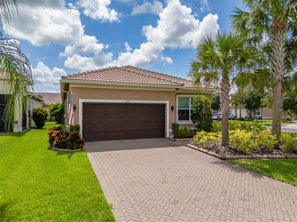 A single-story house with a brown garage door, tiled roof, and a paved driveway — 4905 SANDY GLEN WAY, WIMAUMA, FL