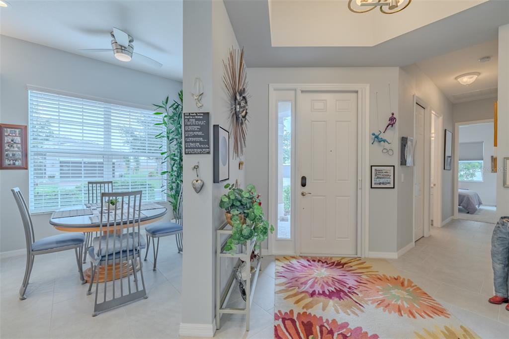An entryway with a floral rug leads to a dining area with a table and chairs — 4905 SANDY GLEN WAY, WIMAUMA, FL