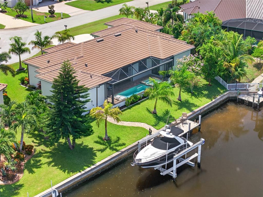 An aerial view of a waterfront house with a screened pool, boat lift, and dock — 1737 CASEY KEY DRIVE, PUNTA GORDA, FL
