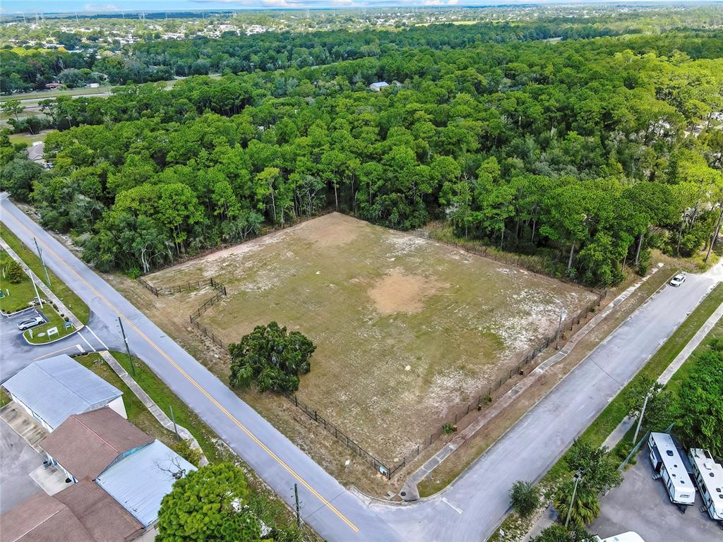 An aerial view shows a fenced, rectangular vacant lot bordered by two paved roads — 15241 HORN AVENUE, BROOKSVILLE, FL