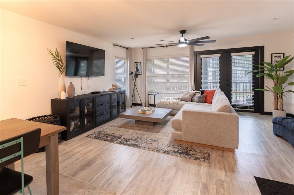 A living room features a sectional sofa, a black media console, and light wood flooring — 528 VINCINDA CREST WAY, TAMPA, FL