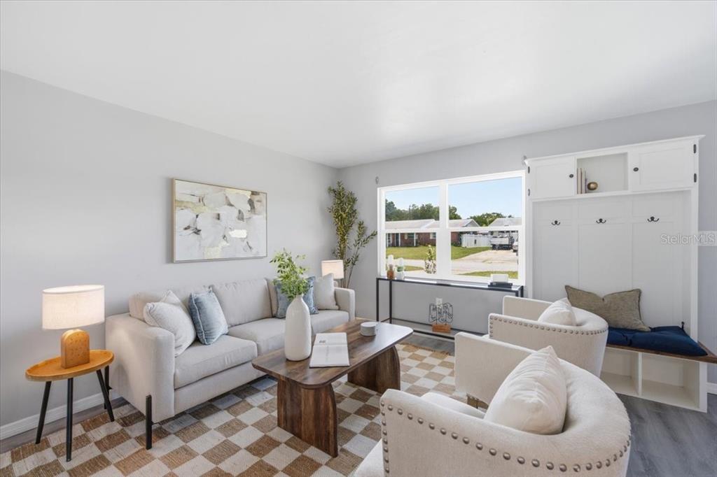 A living room features a light-colored sofa, two armchairs, a coffee table, and built-in shelving — 3568 4TH AVENUE SE, LARGO, FL