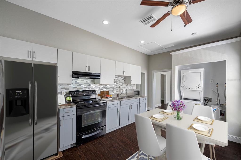 A kitchen with grey cabinets, stainless steel appliances, and a dining table for four — 2118 W PALMETTO STREET, TAMPA, FL
