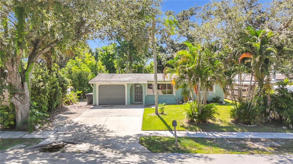 A single-story house with a light green exterior, a gray garage door, and palm trees — 2212 VINSON AVENUE, SARASOTA, FL