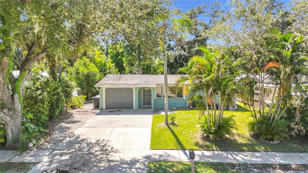 A single-story house with a garage, concrete driveway, and palm trees in the front yard — 2212 VINSON AVENUE, SARASOTA, FL