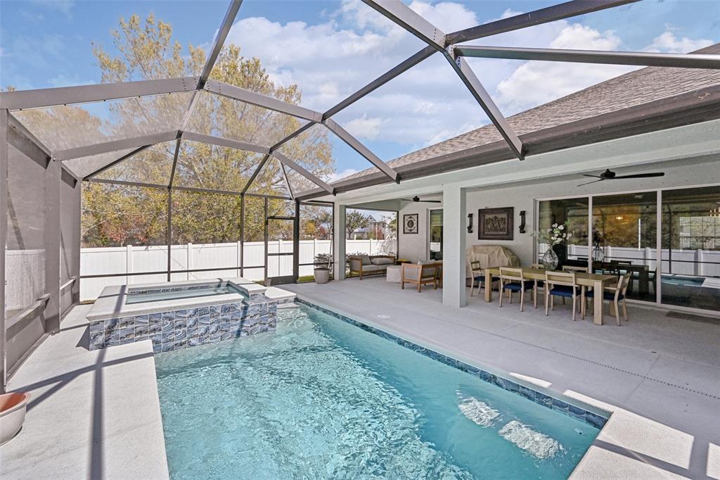 A single-story house with a brick driveway and a white fence under a blue sky — 3955 OAK HOLLOW AVENUE, VERO BEACH, FL