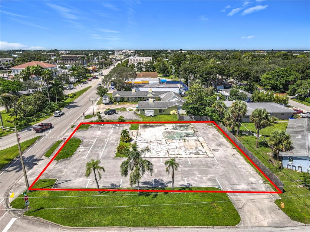 An aerial view shows a vacant paved lot outlined in red with several palm trees — 810 21ST STREET, VERO BEACH, FL