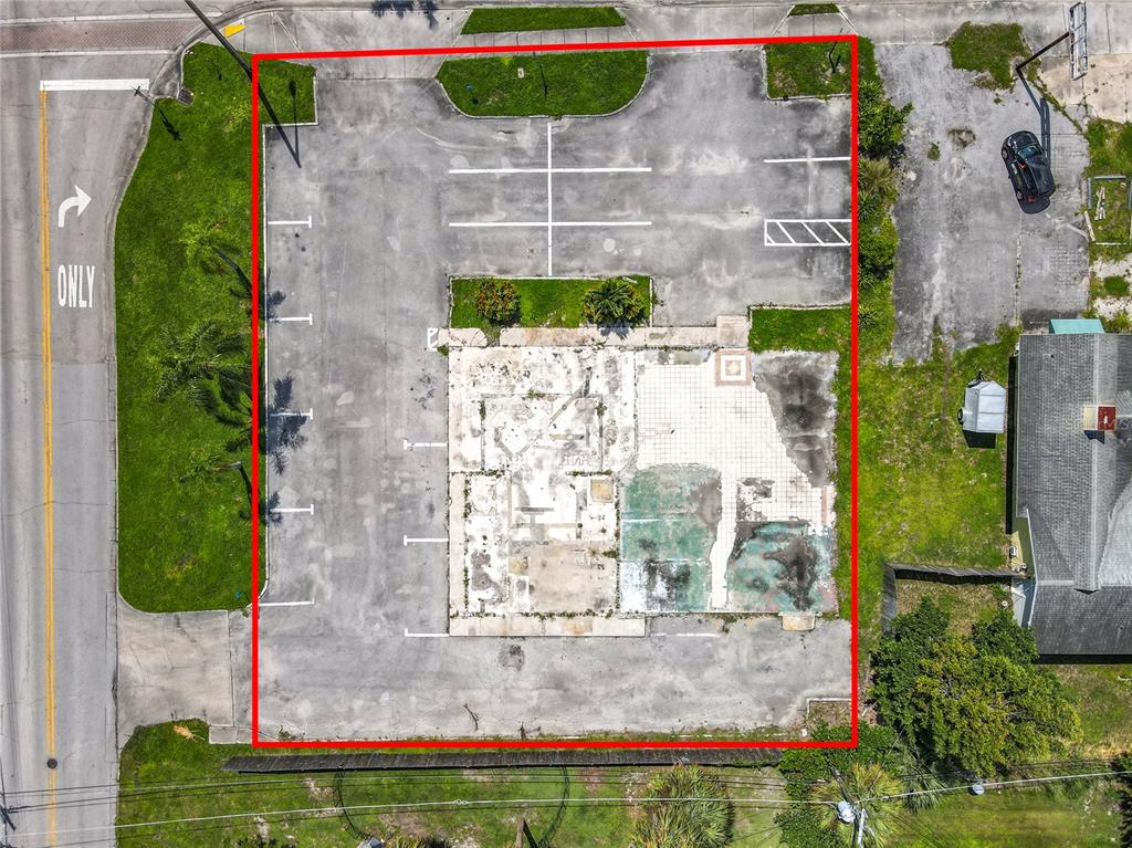 An aerial view shows a rectangular lot containing a concrete building foundation and parking spaces — 810 21ST STREET, VERO BEACH, FL