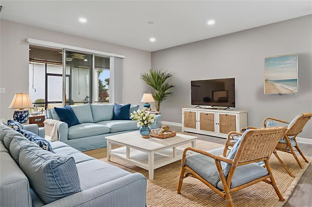 A living room features light blue sofas, a white coffee table, and two rattan chairs — 3464 EMBERS LANE, CLERMONT, FL