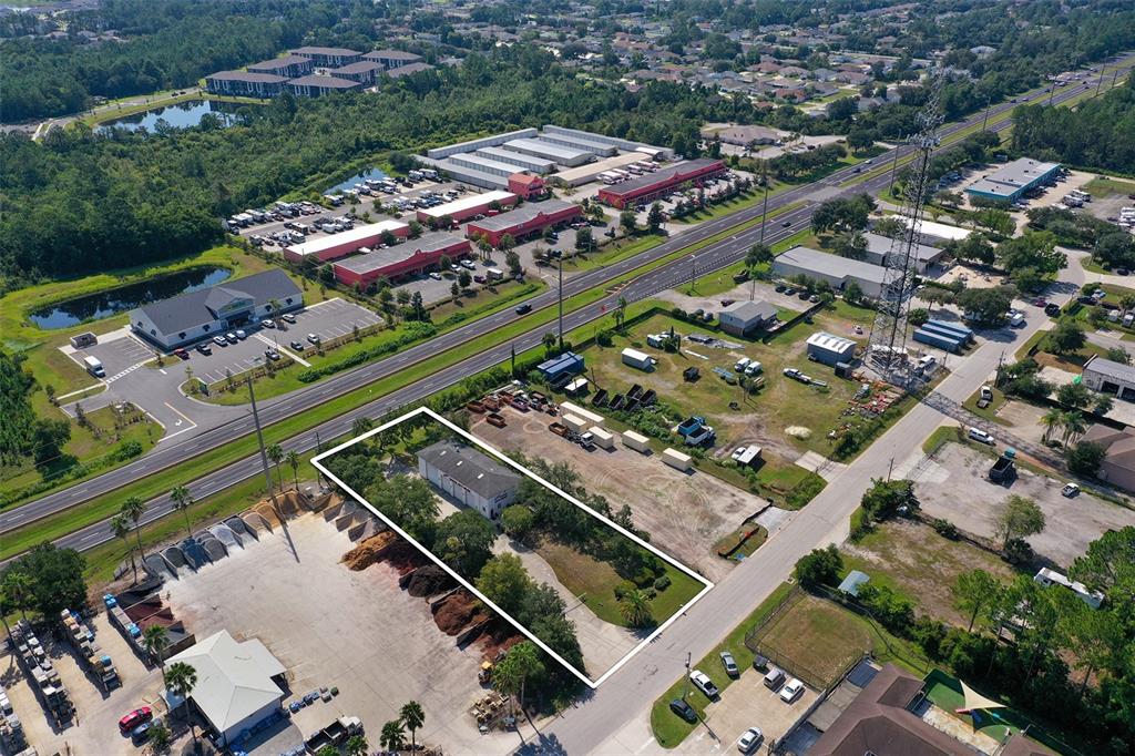 An aerial view shows a rectangular property with a building and trees outlined in white — 10 ENTERPRISE DRIVE, BUNNELL, FL