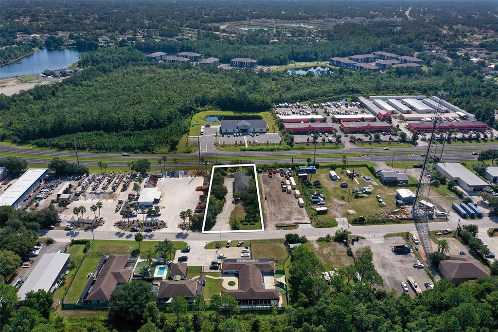 An aerial view shows a rectangular lot with a house surrounded by commercial properties — 10 ENTERPRISE DRIVE, BUNNELL, FL