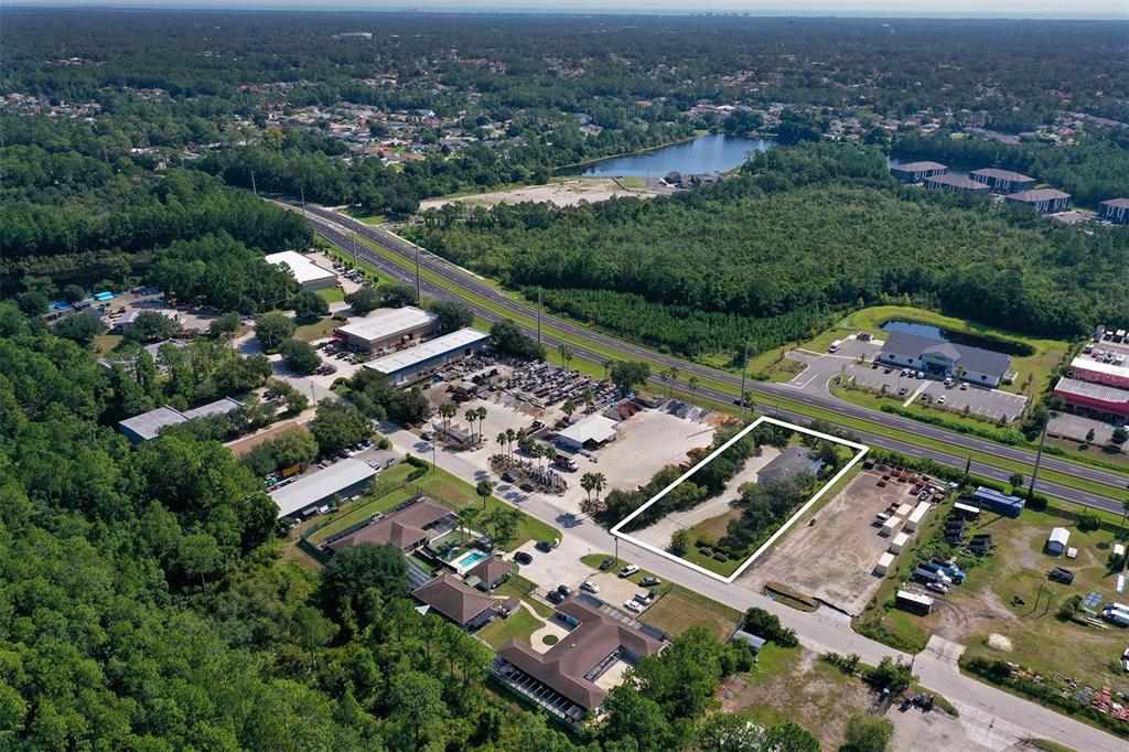 An aerial view shows a rectangular lot with a house surrounded by trees and roads — 10 ENTERPRISE DRIVE, BUNNELL, FL