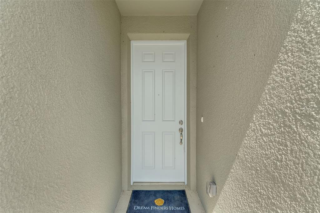 A white six-panel front door is recessed within a stucco-walled entryway — 296 MEREDITH BOULEVARD, WINTER HAVEN, FL