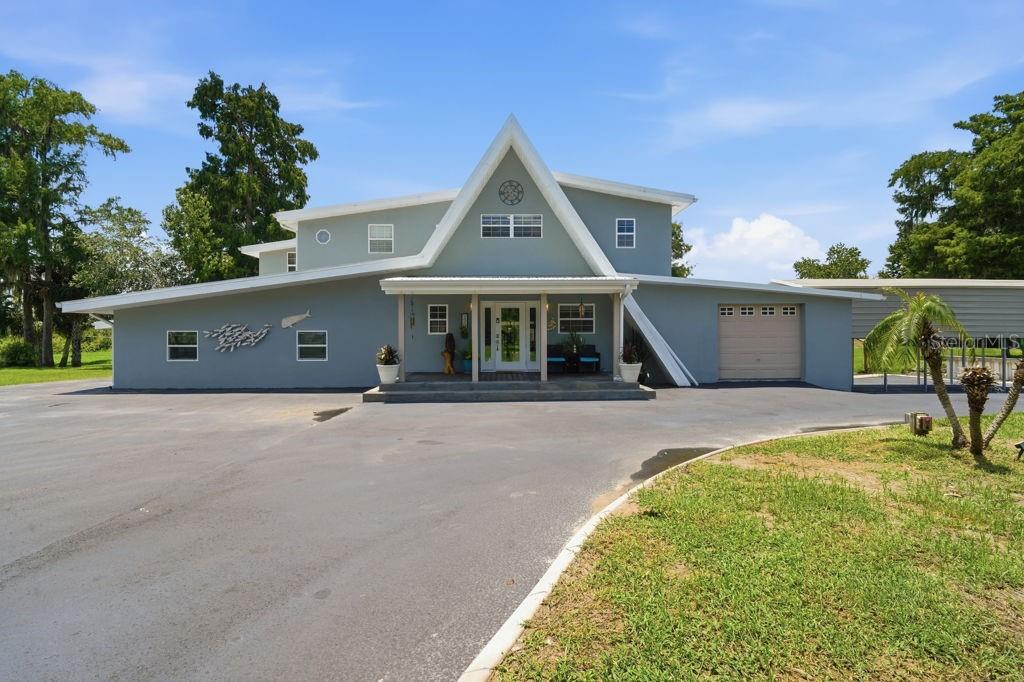 An aerial view of a gray house with a metal roof and a long carport — 220 BRANDY COURT, DELTONA, FL