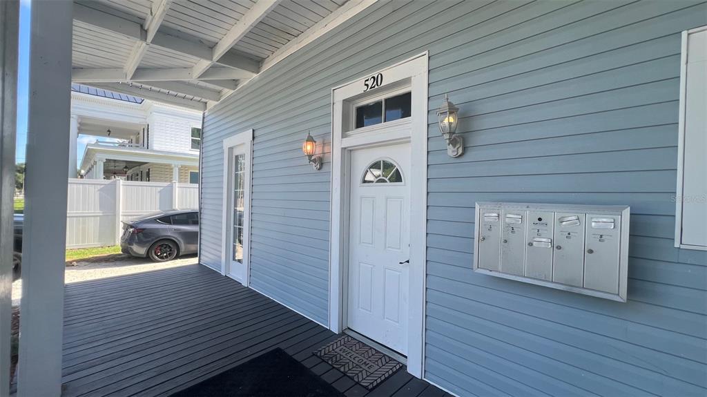 A covered porch with blue siding, a white door, and a row of metal mailboxes — 520 S BROADWAY AVENUE, BARTOW, FL