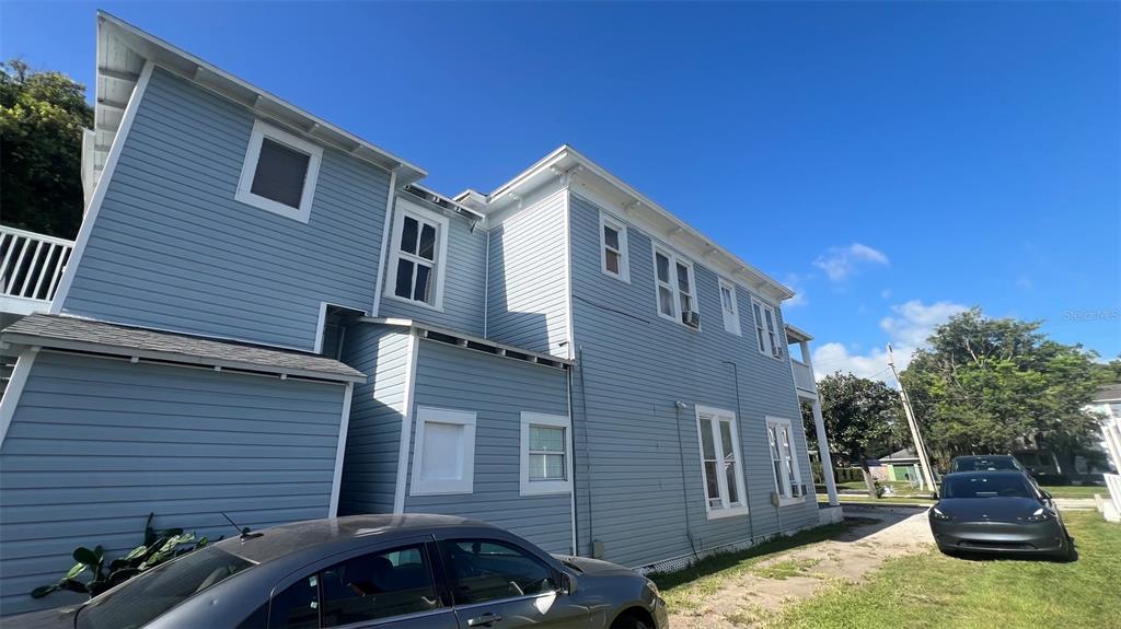 A two-story light blue house with white trim stands next to two parked cars — 520 S BROADWAY AVENUE, BARTOW, FL
