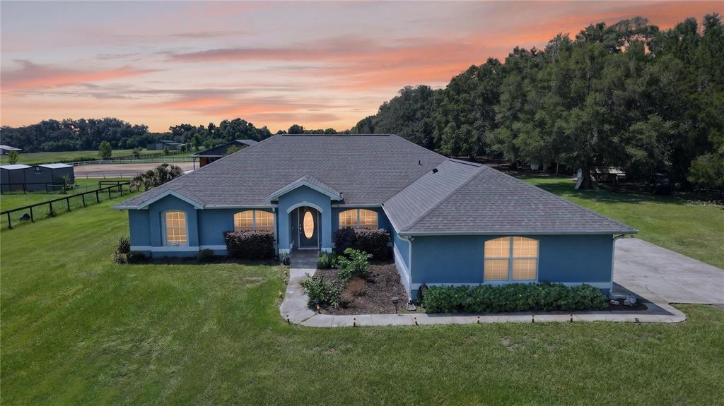 An aerial view of a blue, single-story house with a gray roof and large yard — 20462 SW 36TH STREET, DUNNELLON, FL