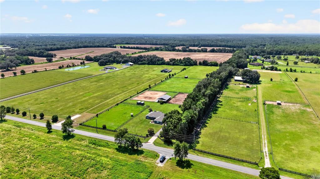 An aerial view shows a rural property with a house, barns, and fenced pastures — 20462 SW 36TH STREET, DUNNELLON, FL