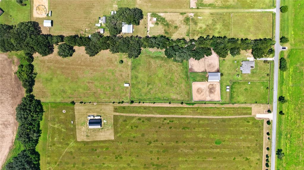An aerial view shows a rural property with a house, barns, and fenced pastures — 20462 SW 36TH STREET, DUNNELLON, FL