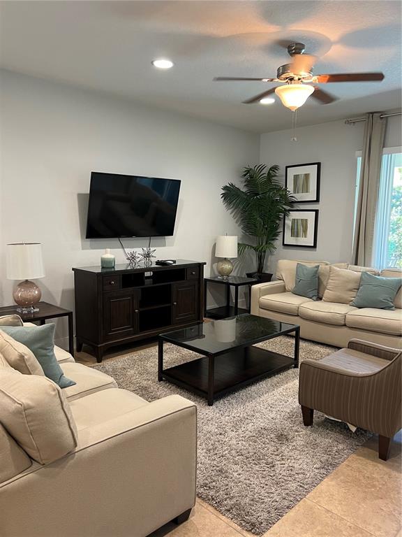 A living room features a television, a coffee table, two sofas, and a ceiling fan — 370 LASSO DRIVE, KISSIMMEE, FL