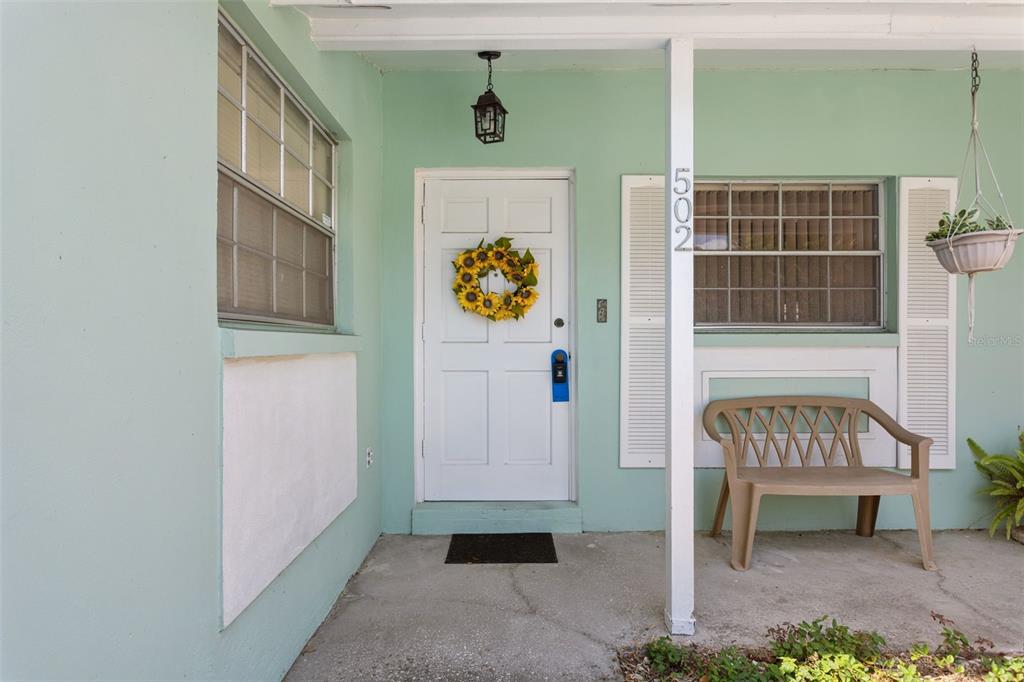 A light green house exterior features a white front door with a sunflower wreath — 502 AVOCADO CIRCLE, BRANDON, FL