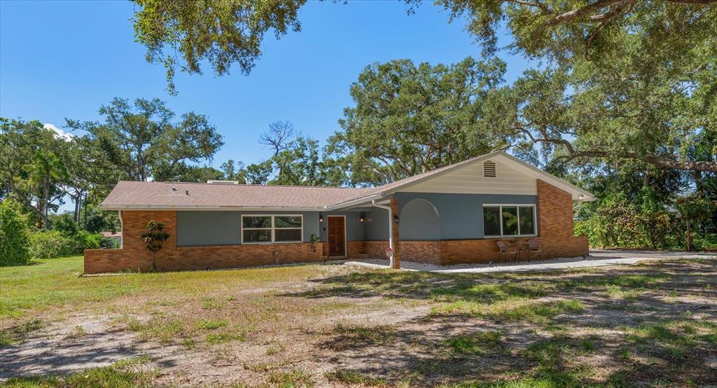 A single-story house with a brick and blue exterior sits on a grassy lot — 13366 108TH AVENUE, LARGO, FL