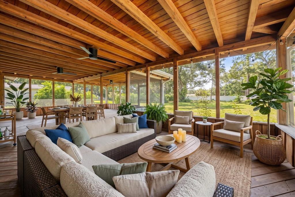 A screened-in porch with wood ceilings, wicker furniture, and a view of a grassy yard — 13366 108TH AVENUE, LARGO, FL