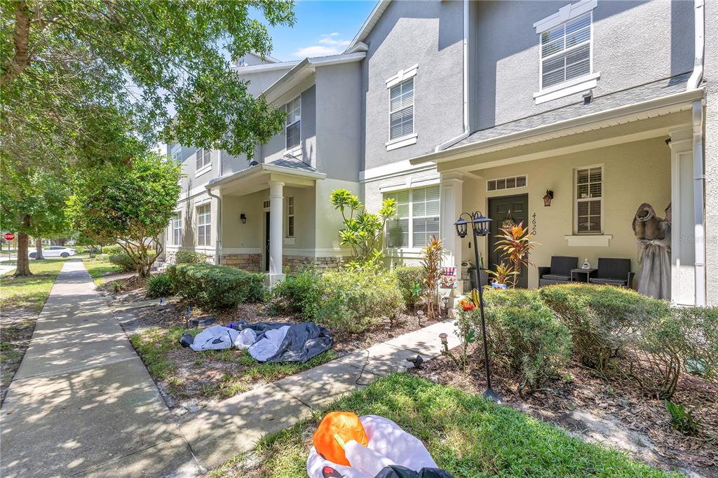 The exterior of a two-story townhouse with a covered porch and Halloween decorations — 4620 CAPITAL BOULEVARD, ST CLOUD, FL
