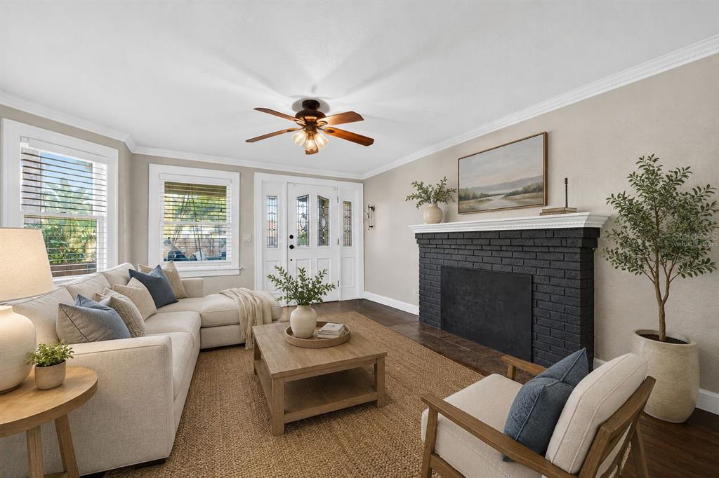 A living room with dark hardwood floors, a brick fireplace, and a bay window — 2419 DARTMOUTH AVENUE N, ST PETERSBURG, FL