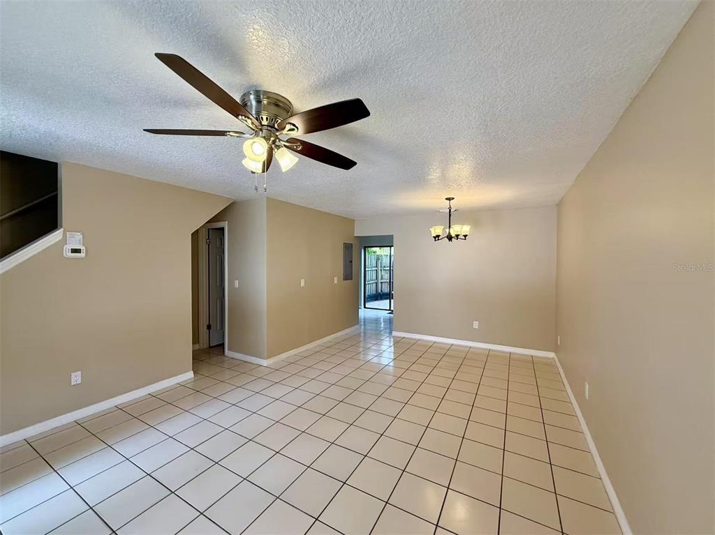 An interior view of a room with beige walls, a ceiling fan, and tiled flooring — 3370 CEDAR SPRINGS PLACE UNIT 156, WINTER PARK, FL