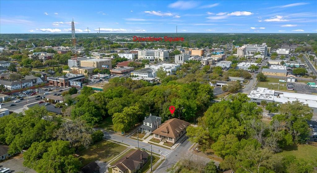 An aerial view shows a residential property with two buildings surrounded by trees near downtown — 118 NE TUSCAWILLA AVENUE, OCALA, FL
