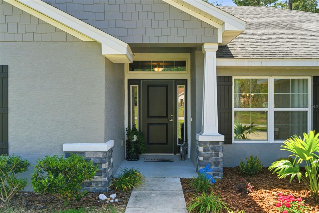 A gray single-story house with a two-car garage and a large front lawn — 47 VILLAGE CENTER DRIVE, HOMOSASSA, FL
