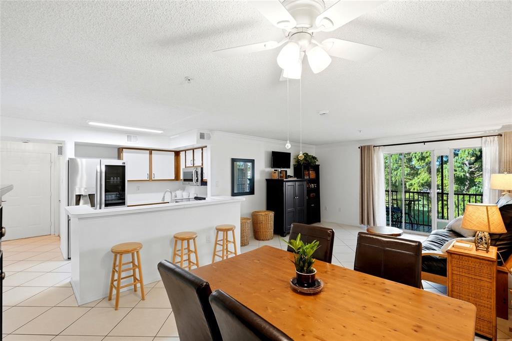 A kitchen with white cabinets, stainless steel appliances, and a breakfast bar overlooking the dining area — 2400 FEATHER SOUND DRIVE UNIT 427, CLEARWATER, FL