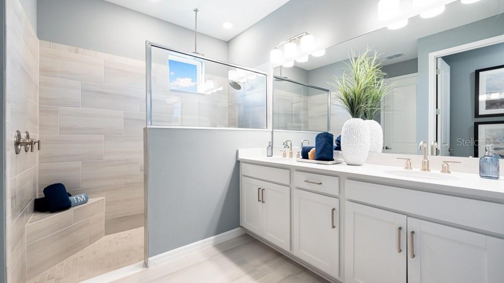 A bright, open-concept kitchen and dining area featuring light wood floors and white cabinetry — 12817 DOCKYARD TRAIL, PALMETTO, FL