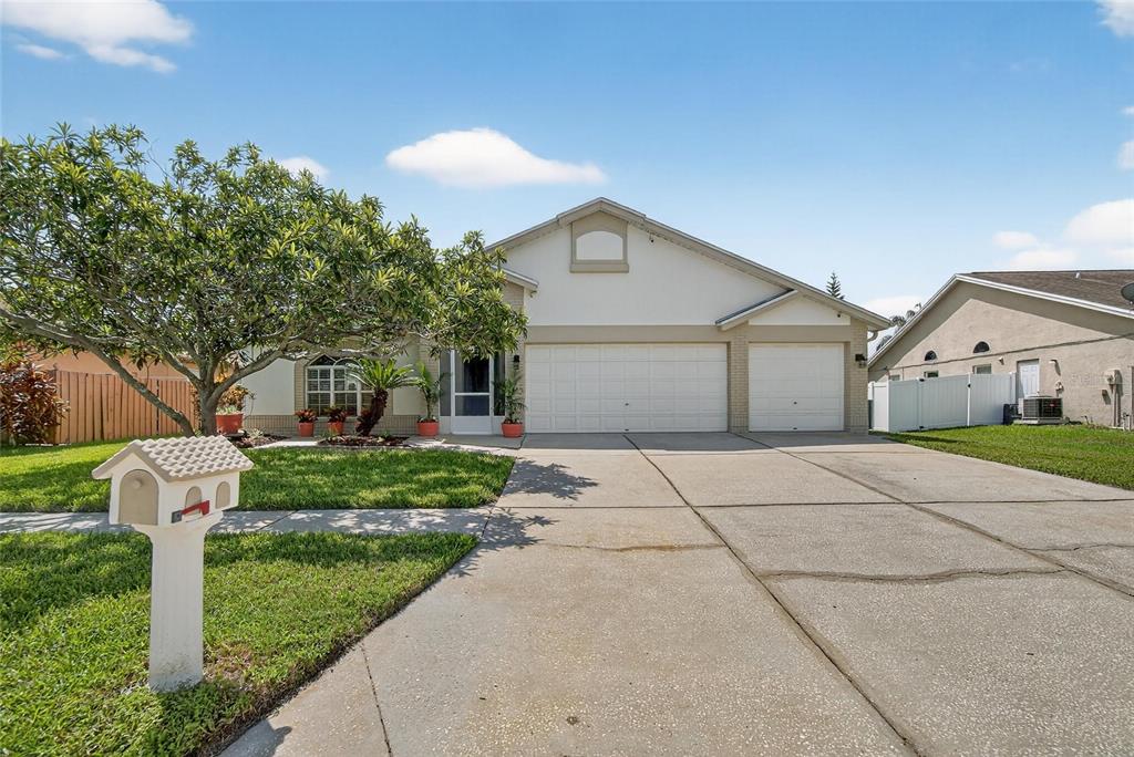 A single-story house with a two-car garage, a concrete driveway, and a front lawn — 13029 PRESTWICK DRIVE, RIVERVIEW, FL