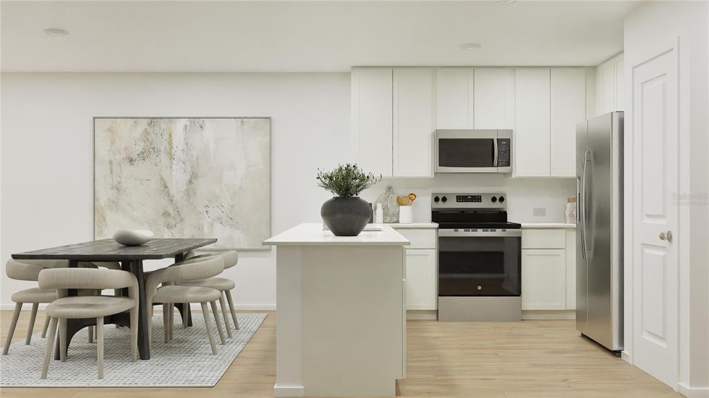 A modern kitchen features white cabinets, stainless steel appliances, a center island, and dining area — 3950 AMERS LOOP, HAINES CITY, FL