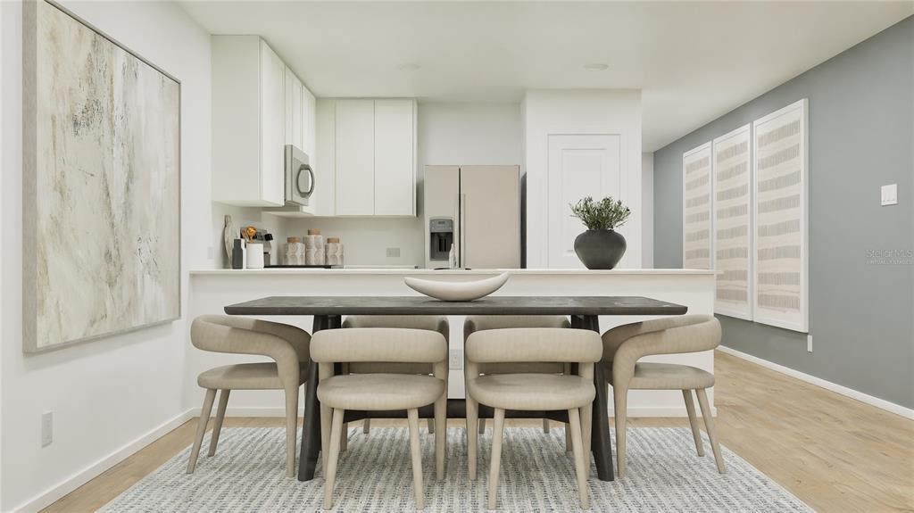 A dining area with a dark table and four chairs sits before an open kitchen — 3950 AMERS LOOP, HAINES CITY, FL