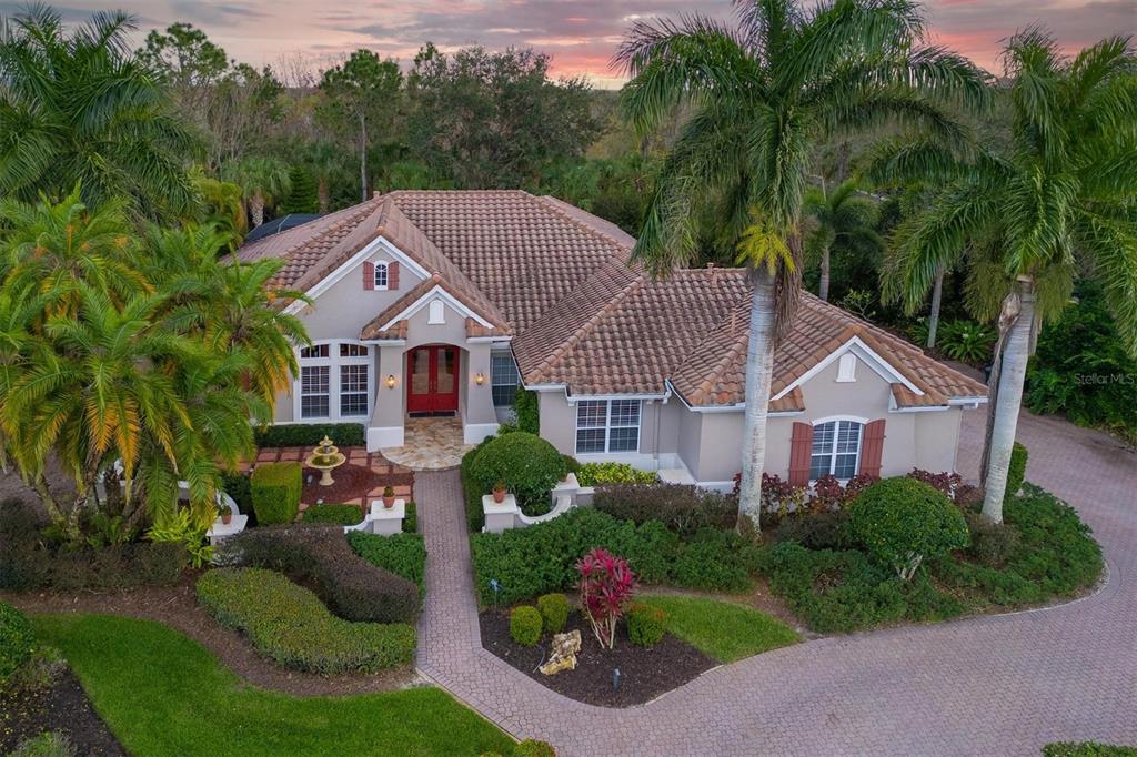 A single-story house with a tiled roof, red double front doors, and a paved walkway — 10006 DISCOVERY TERRACE, BRADENTON, FL