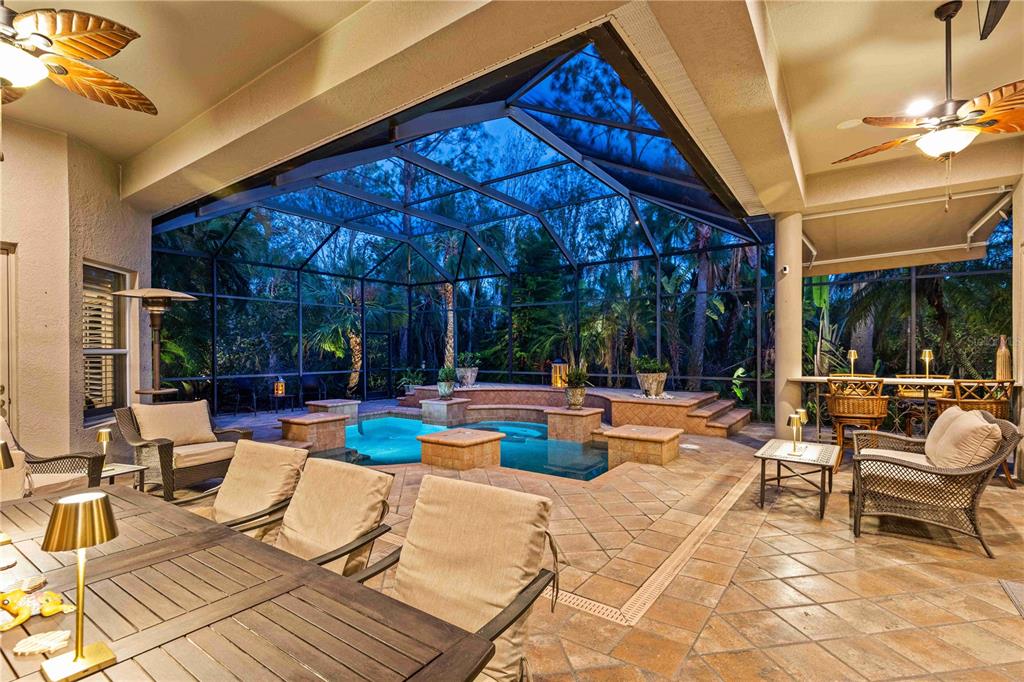 A screened-in patio features a swimming pool, tiled deck, and outdoor seating area — 10006 DISCOVERY TERRACE, BRADENTON, FL