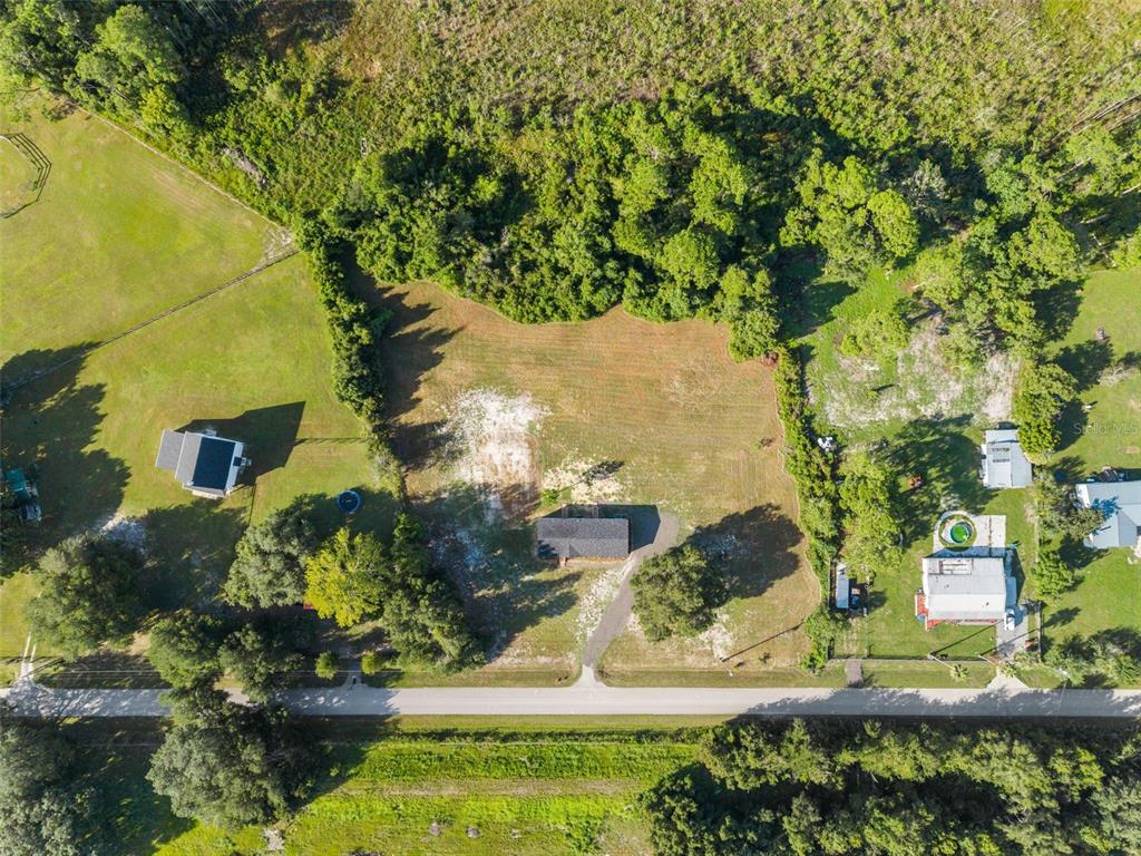 An aerial view shows a house with a driveway on a large, partially wooded lot — 12610 SE 115 STREET, OCKLAWAHA, FL