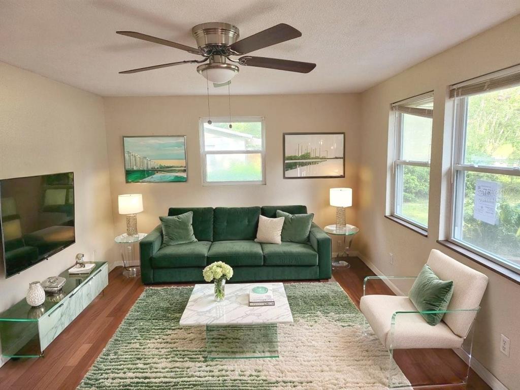A living room features a green sofa, a marble coffee table, and a ceiling fan — 2861 SE 18TH AVENUE, GAINESVILLE, FL